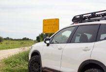 Opony terenowe do Subaru Forester – jak wybrać model dopasowany do szyku jazdy i warunków? Srebrny Subaru Forester z masywnymi oponami terenowymi pokonuje błotnistą drogę w lesie