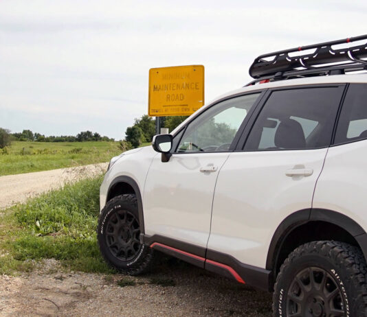 Opony terenowe do Subaru Forester – jak wybrać model dopasowany do szyku jazdy i warunków? Srebrny Subaru Forester z masywnymi oponami terenowymi pokonuje błotnistą drogę w lesie