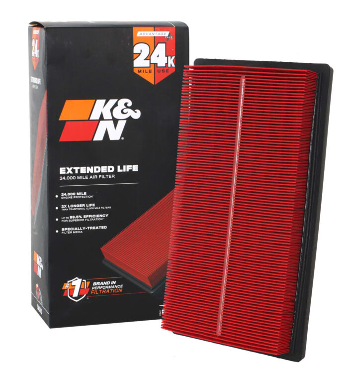 Mechanik pod otwartą maską Toyoty Hybrid wymienia filtr powietrza silnika