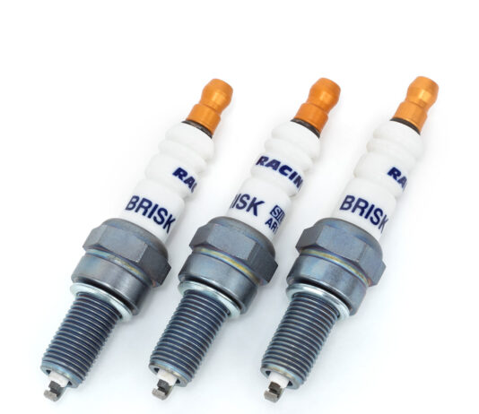 Świece zapłonowe w silniku turbo – kiedy wymiana jest konieczna i jak często ją planować? Mechanik pod otwartą maską samochodu wymienia świece w silniku turbo